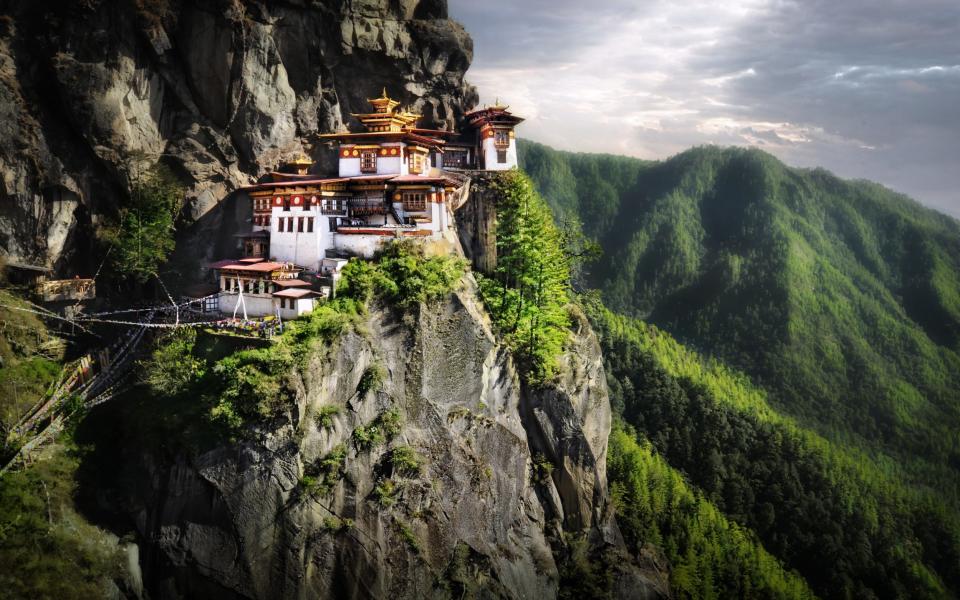 View of Tiger Nest Monastery, perched on a mountainside, high above the forest