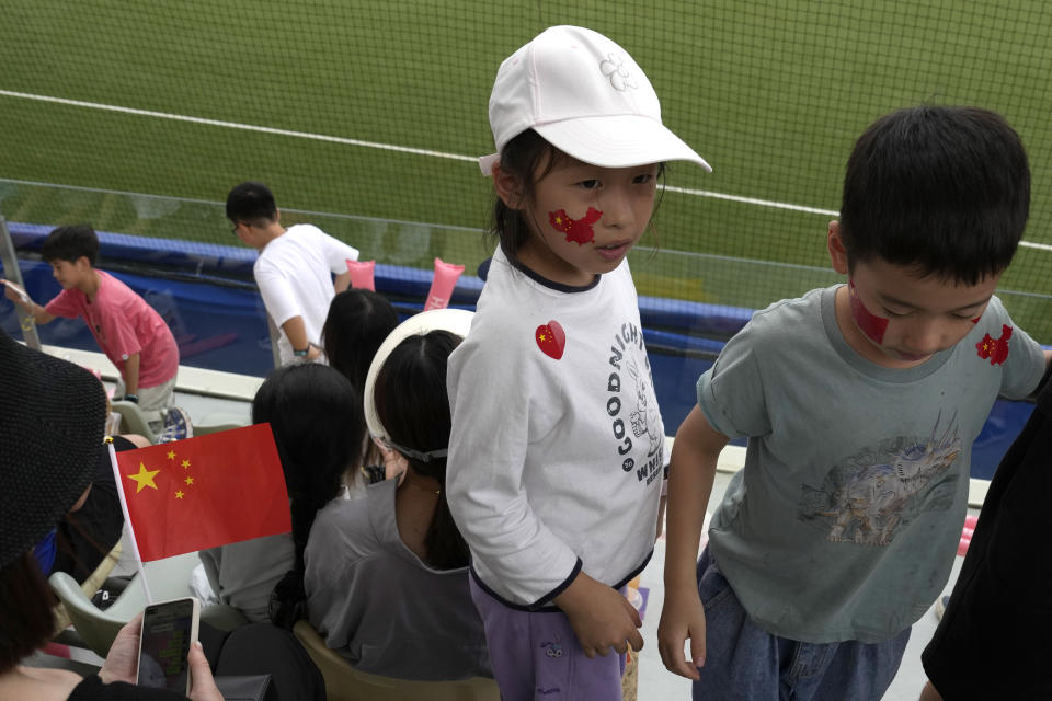 A child wears a face decal in the shape of China's map with the national flag colours attends a stage group round B Baseball Men game between Taiwan and Hong Kong for the 19th Asian Games in Hangzhou, China on Tuesday, Oct. 3, 2023. At the Asian Games China has been going out of its way to be welcoming to the Taiwanese athletes, as it pursues a two-pronged strategy with the goal of taking over the island, which involves both wooing its people while threatening it militarily. (AP Photo/Ng Han Guan)