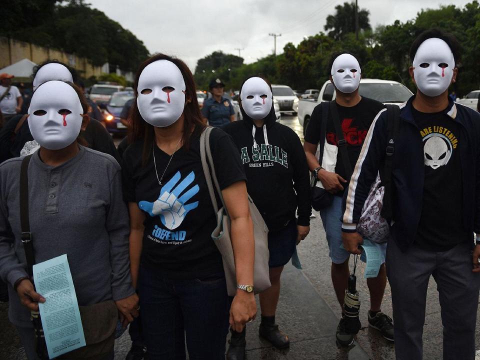 Protesters wearing masks depicting the victims of extra judicial killings taking part in a demonstration against the killings of suspected drug users allegedly by police during anti-drugs raids in Manila (TED ALJIBE/AFP/Getty Images)