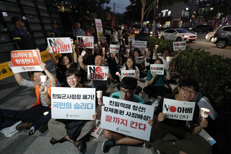 South Korean protesters react during a rally about the General Security of Military Information Agreement, or GSOMIA, in front of Japanese embassy in Seoul, South Korea, Thursday, Aug. 22, 2019. South Korea will stop exchanging classified intelligence on North Korea with Japan amid a bitter trade dispute, an official said Thursday, a surprise announcement that is likely to set back U.S. efforts to bolster security cooperation with two of its most important allies in the Asian region. The sign read "No Abe." and "Welcome, termination of GSOMIA." (AP Photo/Lee Jin-man)