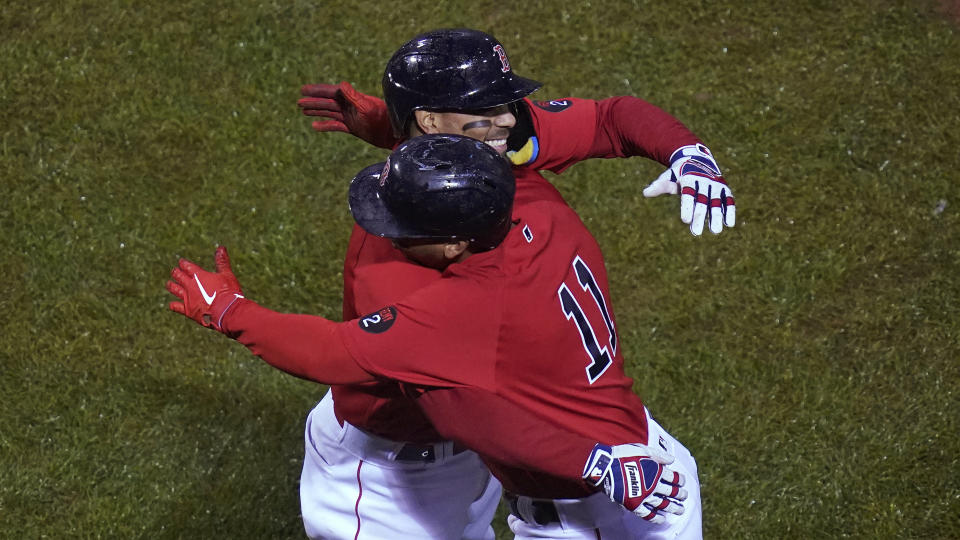 Boston Red Sox's Xander Bogaerts is embraced by Rafael Devers (11) after his grand slam during the fifth inning of the team's baseball game against the Tampa Bay Rays, Tuesday, Oct. 4, 2022, at Fenway Park, in Boston. (AP Photo/Charles Krupa)