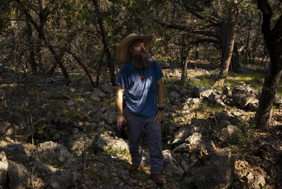 Brandon Kuhn, local cave explorer, walks along caves near the Harrison property in Comal County about halfway between New Braunfels and Bulverde on June 15, 2023. Kuhn is among the residents who raised environmental concerns after Doug Harrison submitted an application for a wastewater treatment plant on his 500-plus-acre plot of land.