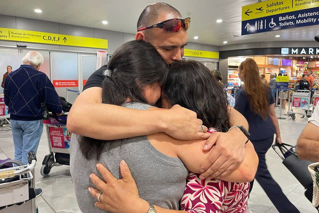 <p>Adam Reid</p> Emily Ours Reid and Sean Ours hugging their biological mother Sara in Chile