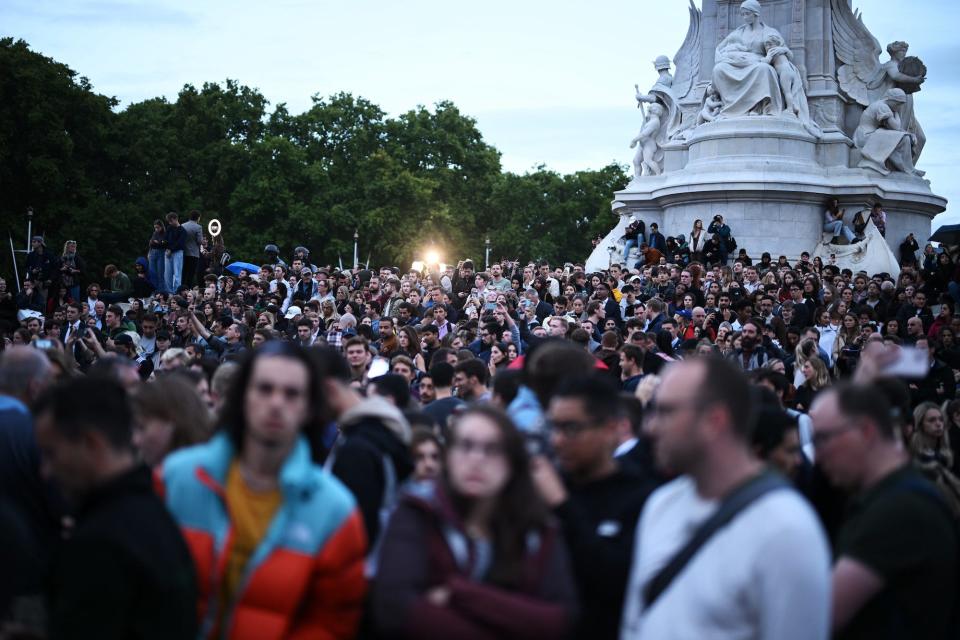 Crowds gather in the twilight in front of Buckingham Palace to pay their respects following the death today of Queen Elizabeth II in Balmoral, on September 8, 2022 in London, England.