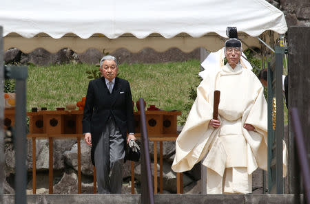 FILE PHOTO: Japan's Emperor Akihito is led by a Shinto priest after visiting the tomb of his late father Hirohito to report his abdication at the Musashino Imperial Mausoleum in Tokyo, Japan April 23, 2019. Koji Sasahara/Pool via REUTERS