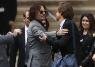 American actor Johnny Depp, left, leaves after the end of the trial at the High Court in London, Tuesday, July 28, 2020. Hollywood actor Johnny Depp is suing News Group Newspapers over a story about his former wife Amber Heard, published in The Sun in 2018 which branded him a 'wife beater', a claim he denies. (AP Photo/Alastair Grant)