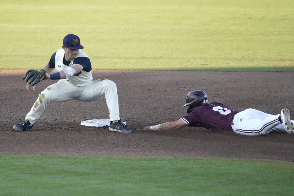 Mississippi State's Kamren James (6) slides safely into second base as Notre Dame infielder Zack Prajzner, left, reaches back to catch the ball at an NCAA college baseball super regional game, Monday, June 14, 2021, in Starkville, Miss. (AP Photo/Rogelio V. Solis)