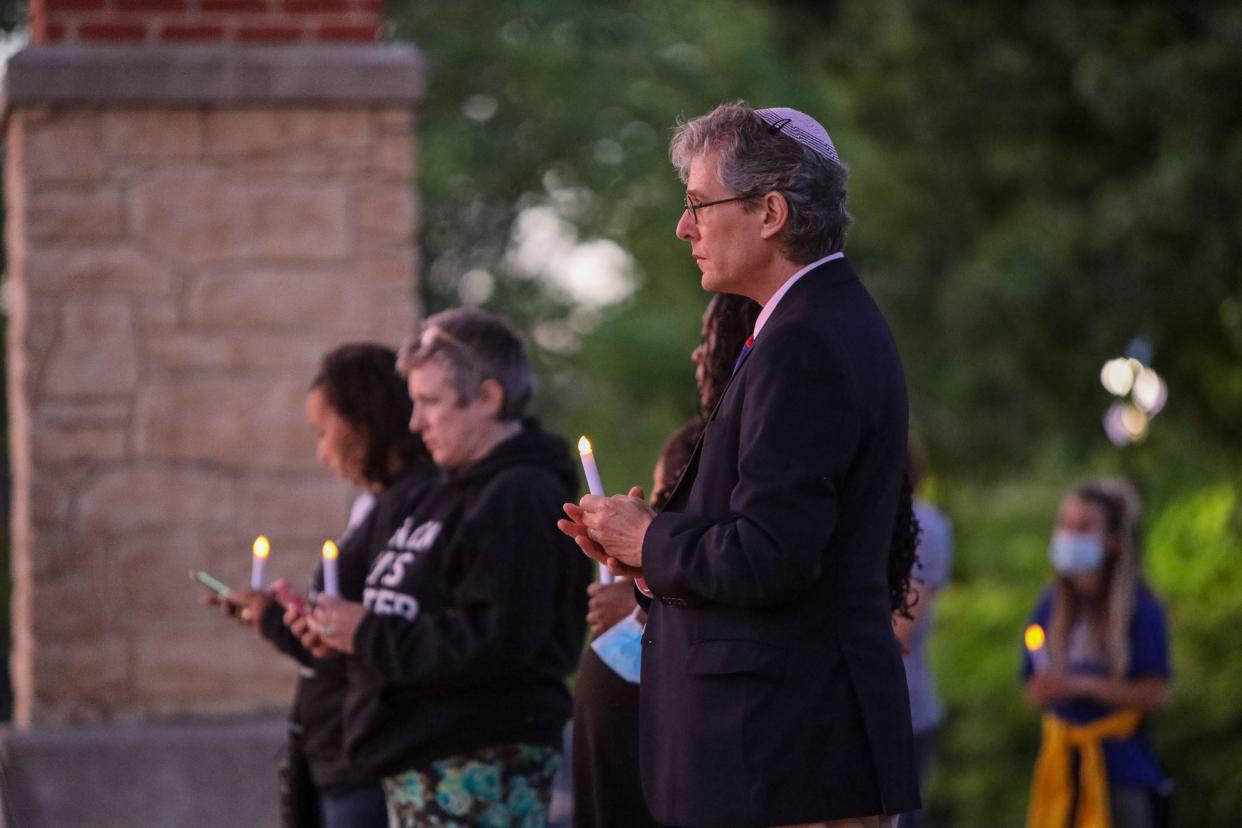 Rabbi Michael Ross, Rabbi of Temple Beth Shalom in Hudson, holds a candle during a candlelight vigil for George Floyd in downtown Cuyahoga Falls.