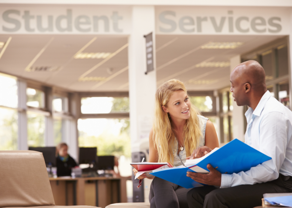 A college student meeting with a tutor at Student Services.