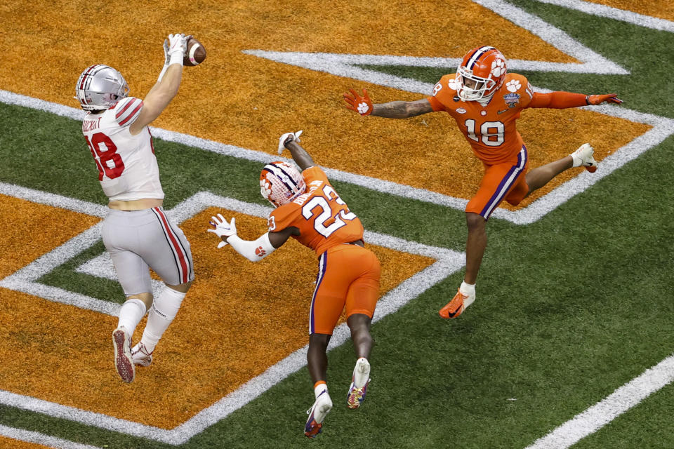 Ohio State tight end Jeremy Ruckert, left, scores in front of Clemson cornerback Andrew Booth Jr. and safety Joseph Charleston during the first half of the Sugar Bowl NCAA college football game Friday, Jan. 1, 2021, in New Orleans. (AP Photo/Butch Dill)