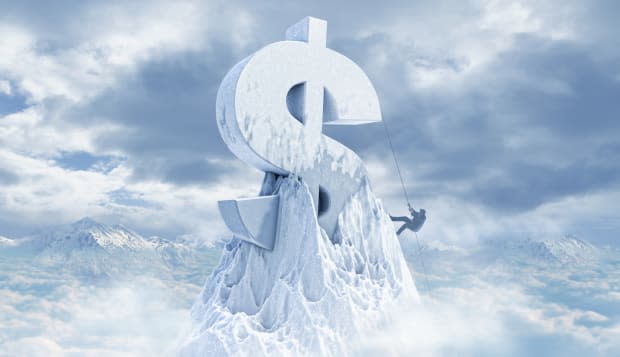 Caucasian man climbing dollar sign on mountaintop