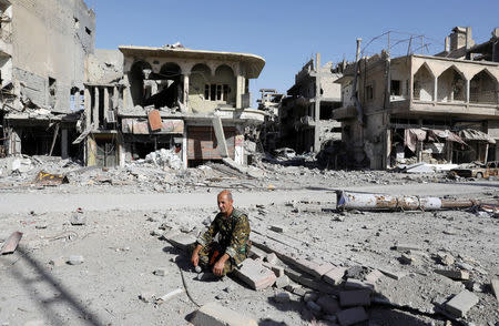 A fighter of Syrian Democratic Forces rests on rubble after Raqqa was liberated from the Islamic State militants, in Raqqa, Syria October 17, 2017. Picture taken October 17, 2017. REUTERS/Erik De Castro