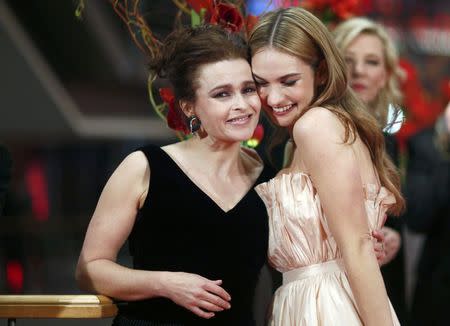 Actors Helena Bonham Carter and Lily James (R) arrive for the screening of the movie 'Cinderella' at the 65th Berlinale International Film Festival in Berlin February 13, 2015. REUTERS/Hannibal Hanschke