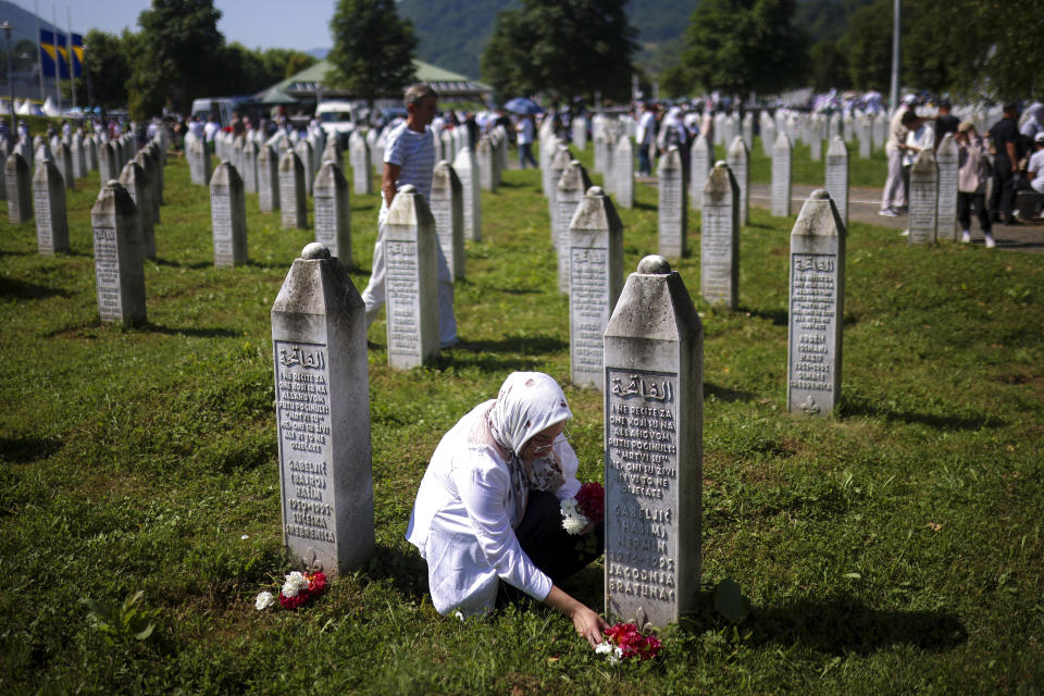 A Bosnian muslim woman lays flowers at the grave of her relative, victim of the Srebrenica genocide, at the Srebrenica Memorial Centre, in Potocari, Bosnia, Thursday, July 11, 2024. Thousands gather in the eastern Bosnian town of Srebrenica to commemorate the 29th anniversary on Monday of Europe's only acknowledged genocide since World War II. (AP Photo/Armin Durgut)