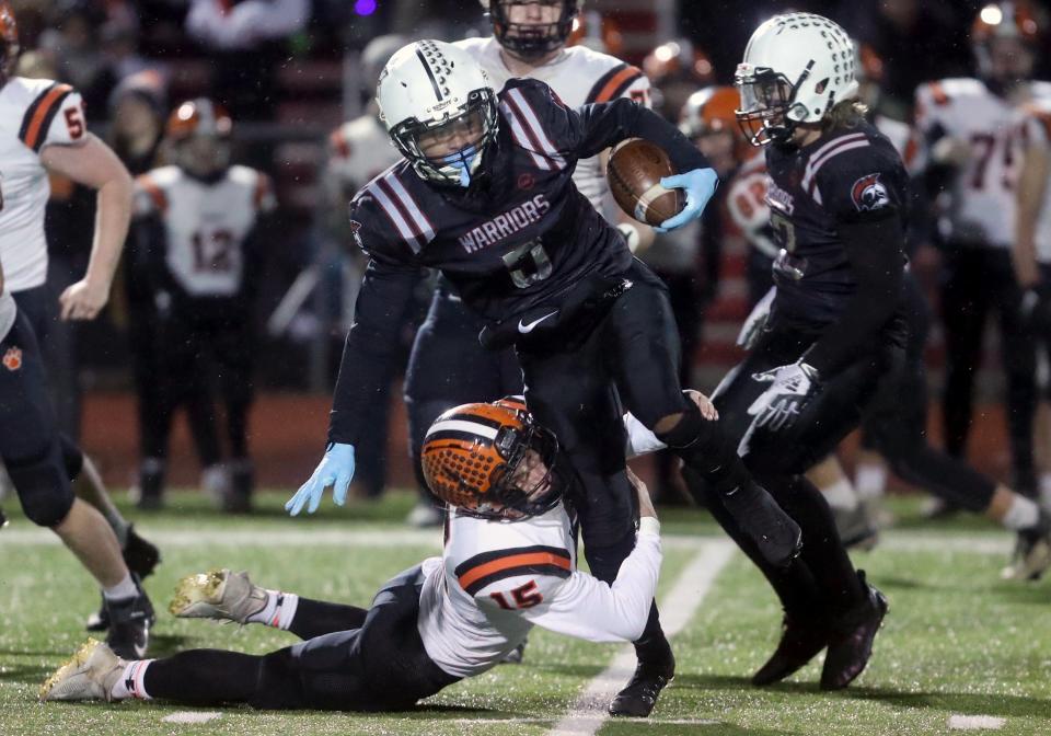 Versailles' Landon Henry tackles Harvest Prep's Artrell Saunders after a reception during a Division V OHSAA State Semifinal game Nov. 27, 2021, at London High School in London, Ohio.