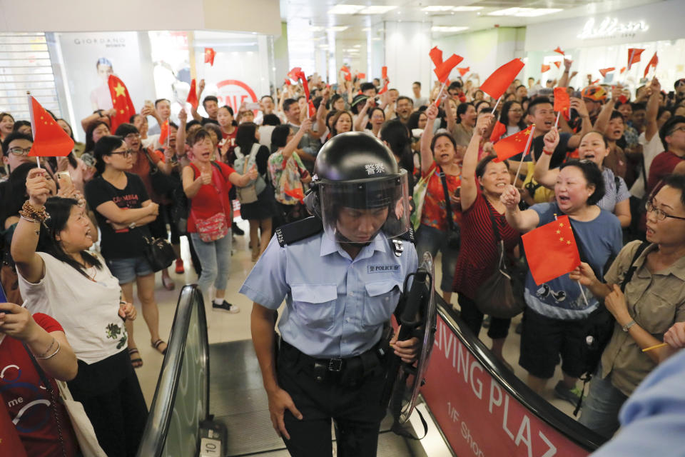 Pro-China supporters cheer after riot police arrived at the Kowloon Bay district in Hong Kong, Saturday, Sept. 14, 2019. Skirmishes broke out Saturday between supporters of the ongoing protests for democratic reforms in Hong Kong and supporters of the central government at a shopping mall in the semiautonomous Chinese territory. (AP Photo/Kin Cheung)