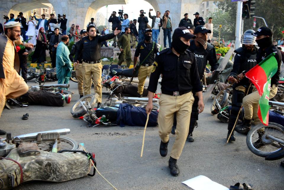 Police officers gesture next to fallen motorbikes of supporters of former prime minister Imran Khan's party, (REUTERS)