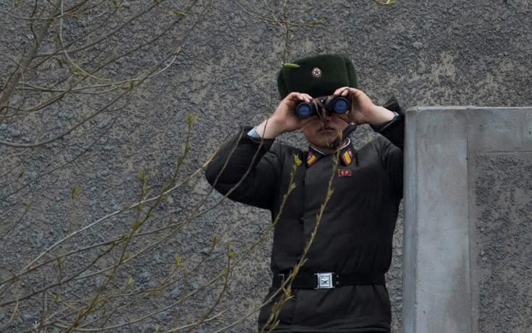 A North Korean soldier gazes across the Yalu border river near Sinuiju, opposite the Chinese city of Dandong, on April 14, 2017