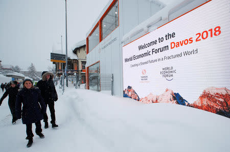 People walk in the snow ahead of the World Economic Forum (WEF) annual meeting in the Swiss Alps resort of Davos, Switzerland January 21, 2018 REUTERS/Denis Balibouse