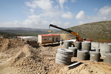 File Photo: A crane lowers a caravan to the ground in Amichai, a new settlement which will house some 300 Jewish settlers evicted in February 2017 from the illegal West Bank settlement of Amona, in the Israeli occupied West Bank, February 22, 2018. REUTERS/Ammar Awad/File Photo