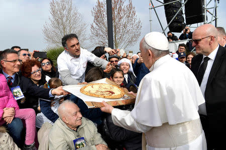 Faithful present pizza to Pope Francis during his pastoral visit in Pietrelcina, Italy March 17, 2018. Osservatore Romano/Handout via REUTERS
