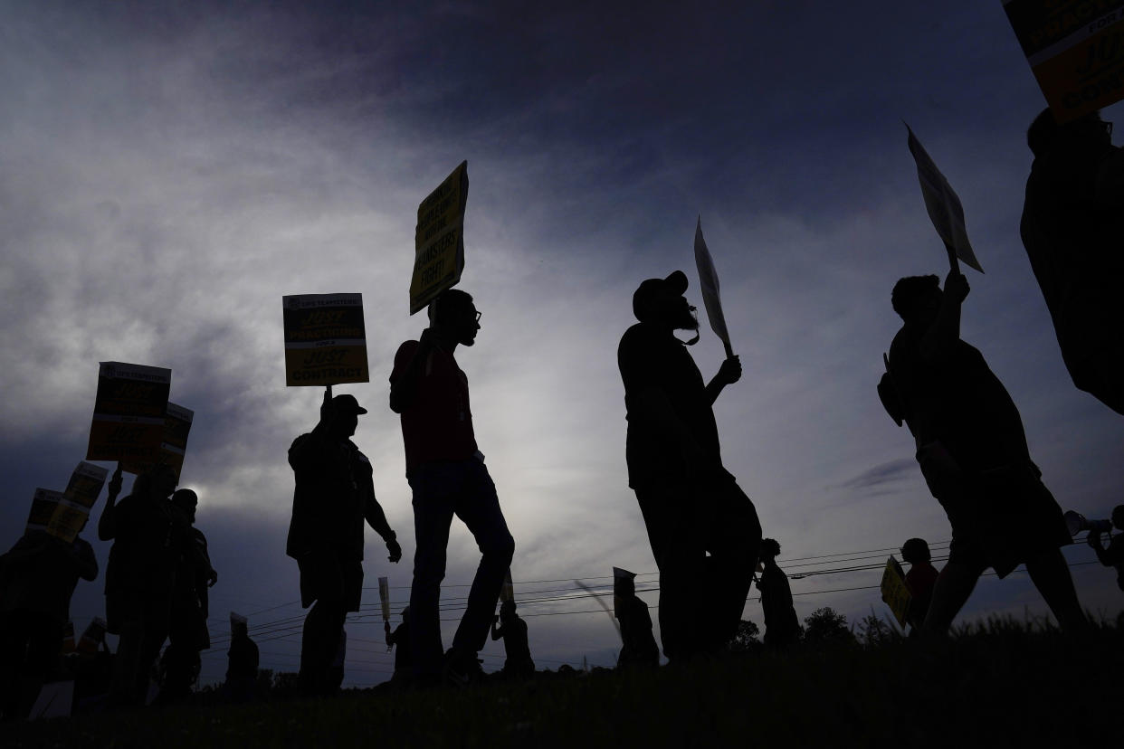 Workers carry signs.