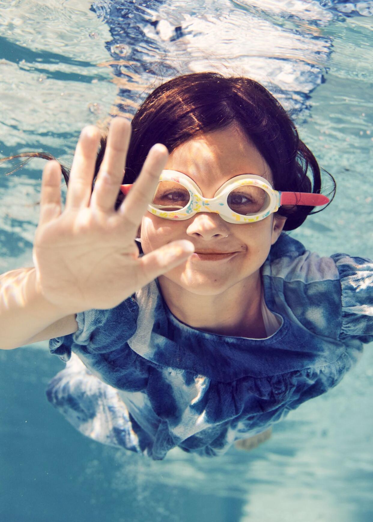 kid underwater wearing goggles