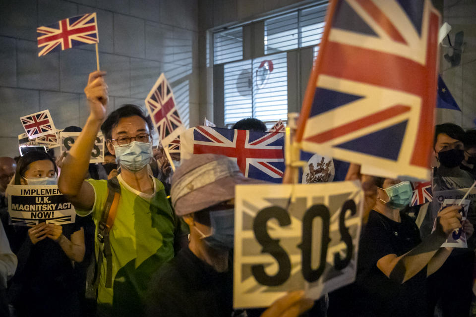 Demonstrators wave British flags during a rally outside of the British Consulate in Hong Kong, Wednesday, Oct. 23, 2019. Some hundreds of Hong Kong pro-democracy demonstrators have formed a human chain at the British consulate to rally support for their cause from the city's former colonial ruler. (AP Photo/Mark Schiefelbein)