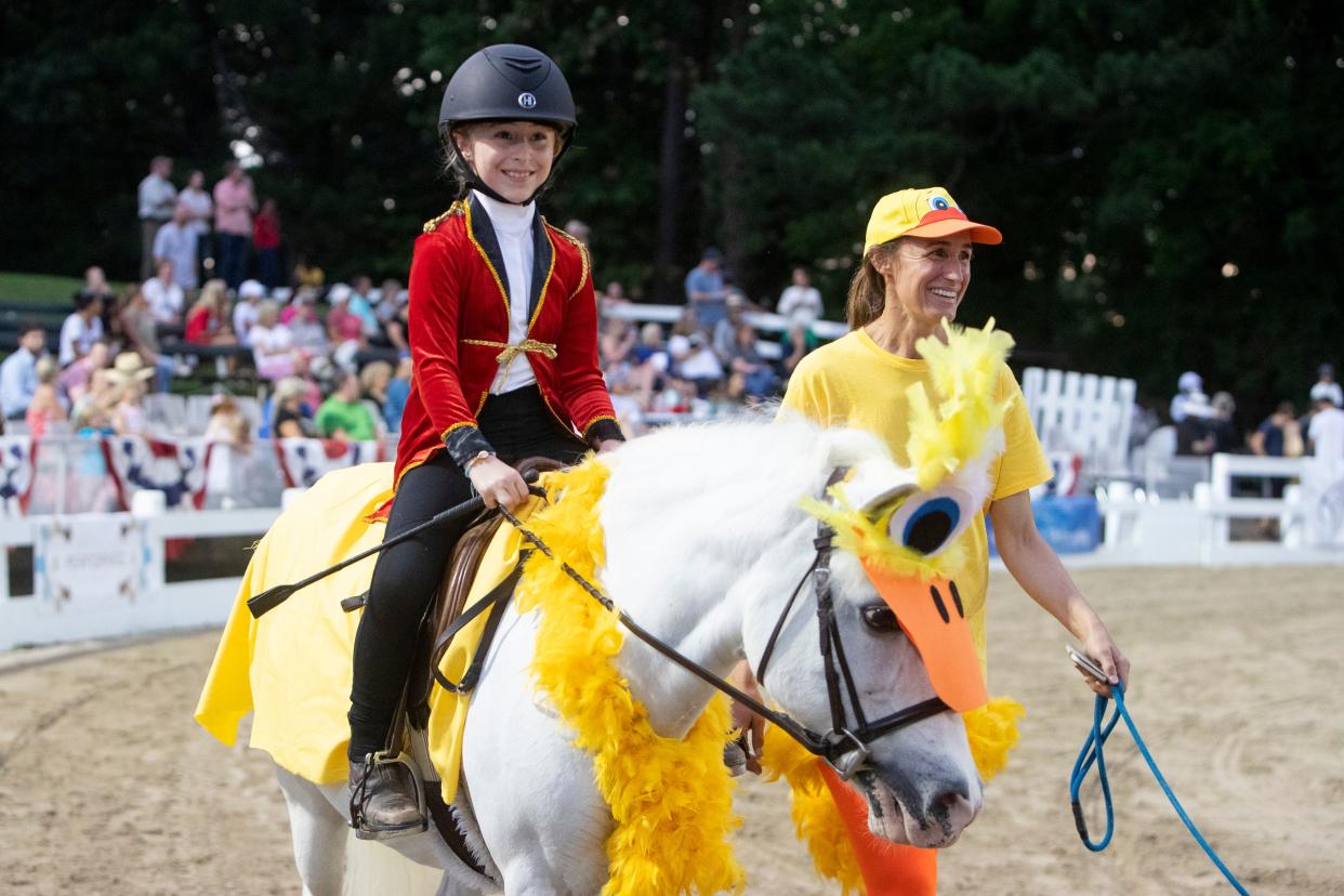 Georgia Fant, 7, dressed as the Peabody Hotel Duckmaster rides Rosie, who is dressed as one of the ducks, as her mom Ashley Fant walks next to her as another duck while they compete in the Rachael Smith Memorial Costume Class during the Germantown Charity Horse Show in Germantown, Tenn., on Tuesday, June 4, 2024.