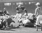FILE - Fullback Jim Brown of the Cleveland Browns hurdles through a big hole for a 3-yard touchdown run in the first quarter of a football game against the Chicago Cardinals, Oct. 12, 1958 in Cleveland. NFL legend, actor and social activist Jim Brown passed away peacefully in his Los Angeles home on Thursday night, May 18, 2023, with his wife, Monique, by his side, according to a spokeswoman for Brown's family. He was 87. (AP Photo/File)