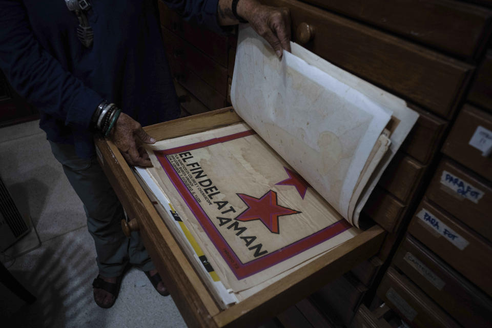 Sara Vega, especialista de la Cinemateca cubana, muestra un poster promocional de una película durante una entrevista en la Cinemateca en La Habana, el martes 11 de julio de 2023. El listado de Memoria del Mundo de la UNESCO ahora incluye una colección de seis décadas de carteles impresos en serigrafía de películas cubanas. (AP Foto/Ramón Espinosa)