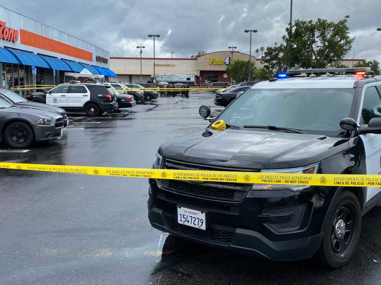 LAPD tape blocks off the scene where officers shot a man who they allege had threatened his estranged wife family and presented a gun as officers ordered him out of his vehicle near her workplace.