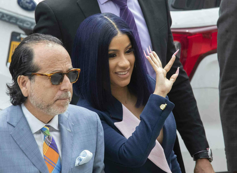 Grammy-winning rapper Cardi B, right, waves at fans as she arrives for a hearing at Queens County Criminal Court, Tuesday, June 25, 2019, in New York. (AP Photo/Mary Altaffer)