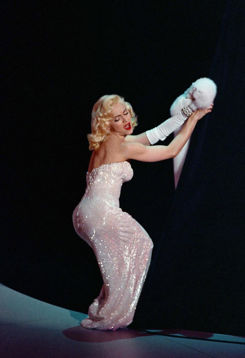 FILE - In this March 25, 1991 file photo, Madonna performs “Sooner or Later (I Always Get My Man)” from the film “Dick Tracy” during the 63rd Annual Academy Awards show at the Shrine Auditorium, in Los Angeles. The song won an Oscar for best song. Madonna has famously appropriated Marilyn Monroe's look into her image. Monroe passed away a half-century ago this week, a murky death that remains one of Hollywood's most tantalizing mysteries. But look around: Her legend lives on, more vibrantly than ever. In a twist she surely would have appreciated, this 1950's bombshell has become a 21st-century pop culture phenom. (AP Photo/Reed Saxon, File)