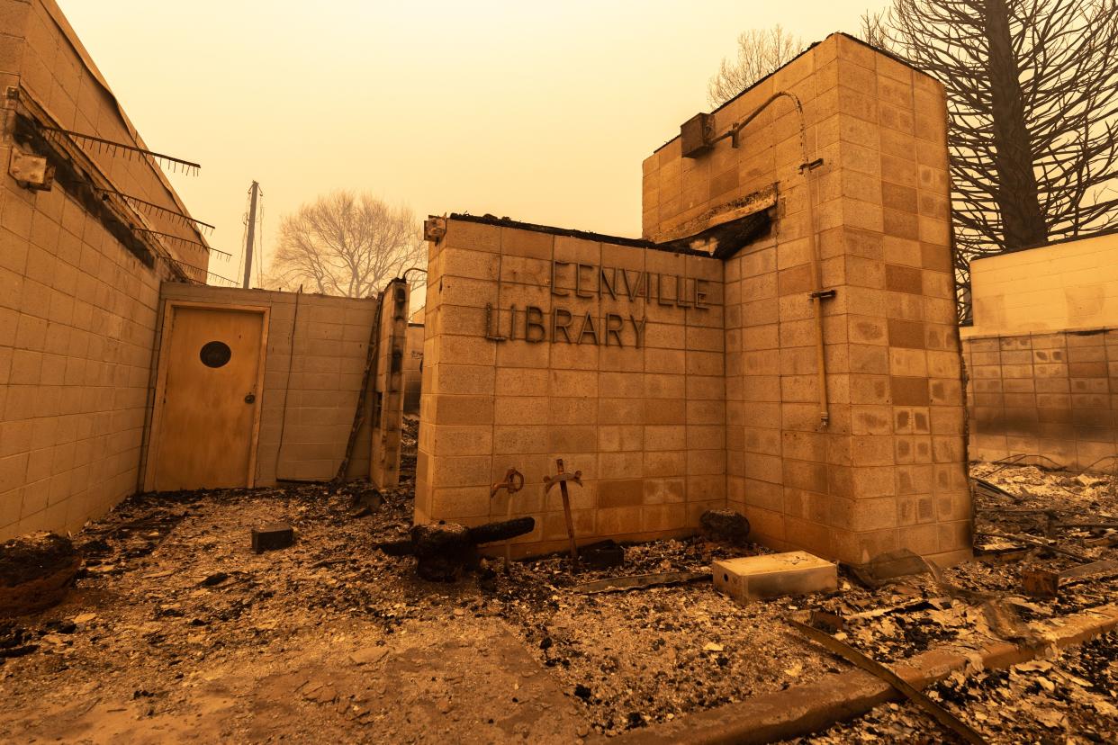 The Greenville Library is surrounded by rubble as the Dixie Fire continues to burn on Aug. 6, 2021, in Greenville, Calif. The Dixie Fire burned through the community two days prior, destroying most of the town.