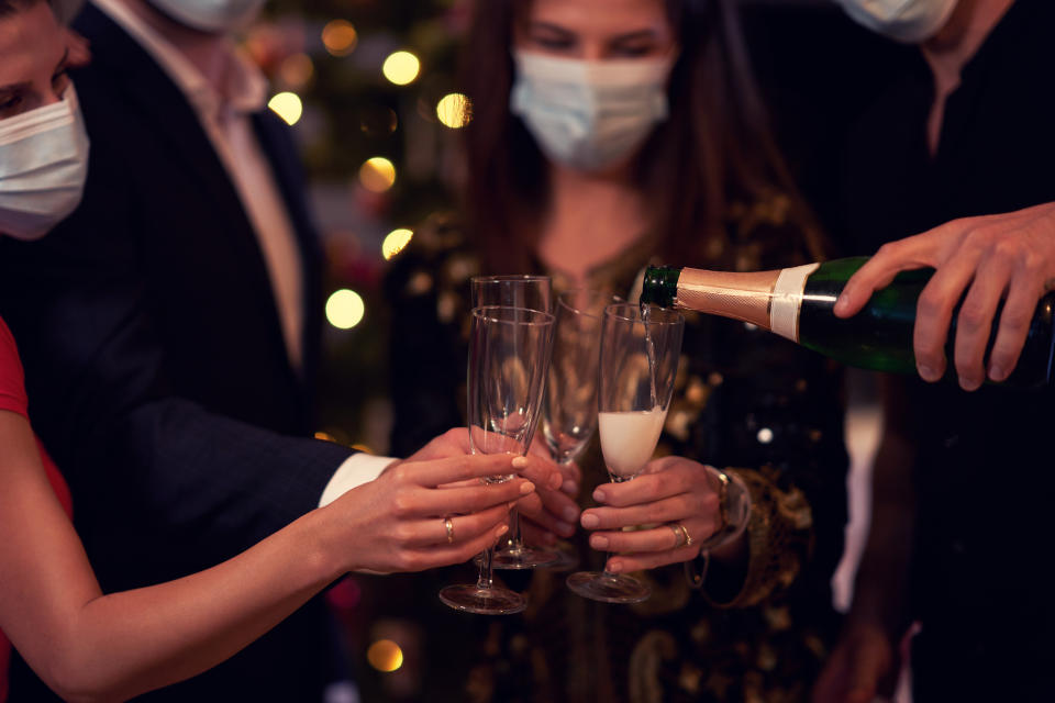 Two beautiful young couples having fun at New Year's Eve Party holding numbers 2020