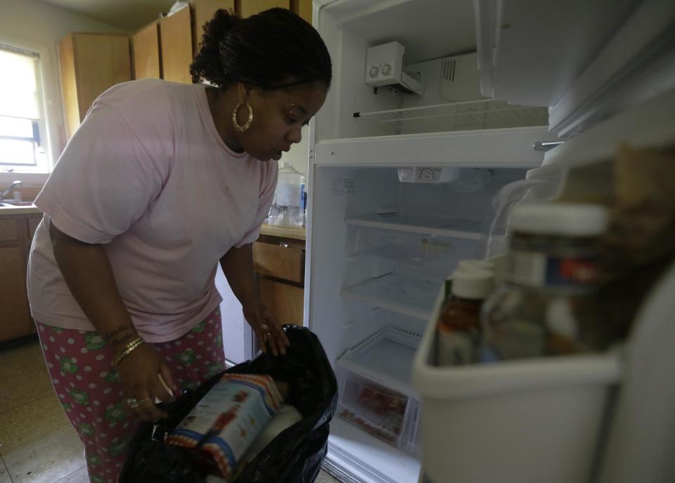 Jermeda Green, whose apartment lost power in the aftermath of a storm, empties spoiled food from her refrigerator, Tuesday, July 3, 2012, in Salem, N.J. More then a million customers from North Carolina to New Jersey and as far west as Illinois were without power Monday morning after a round of summer storms. (AP Photo/Matt Rourke)