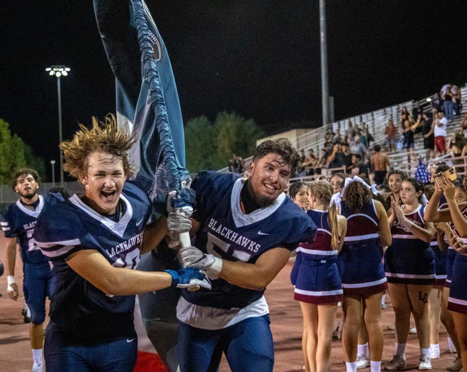 La Quinta's Mark Levine (10) and Omar Osorio (51) run with the flag after winning it back in the flag game at La Quinta High School in La Quinta, Calif., Friday, Sept. 30, 2022. 