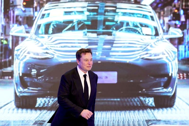 FILE PHOTO: Tesla Inc CEO Elon Musk walks next to a screen showing an image of Tesla Model 3 car during an opening ceremony for Tesla China-made Model Y program in Shanghai