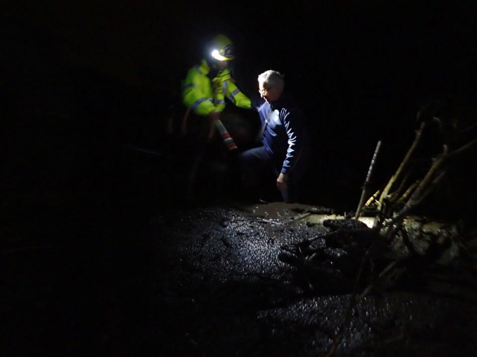 A man is rescued from flood waters and debris in Montecito.