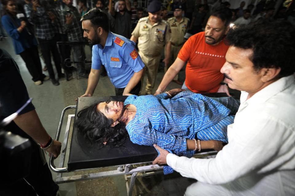 An injured woman is brought to the Government Medical College Hospital in Jammu after the bus she was traveling in fell into a deep gorge in the Pouni area of Jammu's Reasi district, India, Sunday, June 9, 2024. Officials in Indian-controlled Kashmir say at least nine people have been killed after suspected militants fired at a bus with Hindu pilgrims, which then fell into a deep gorge. (AP Photo/Channi Anand)