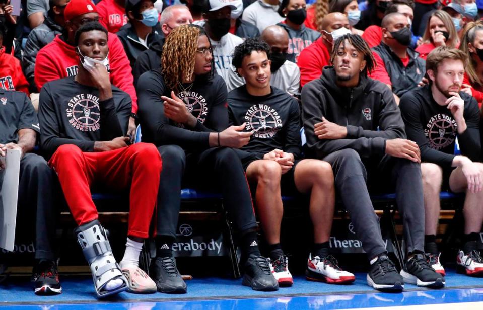 From left, N.C. State’s Ernest Ross, Greg Gantt, Chase Graham, Manny Bates and Alex Nunnally sit on the bench during the first half of Duke’s game against N.C. State at Cameron Indoor Stadium in Durham, N.C., Saturday, January 15, 2022.