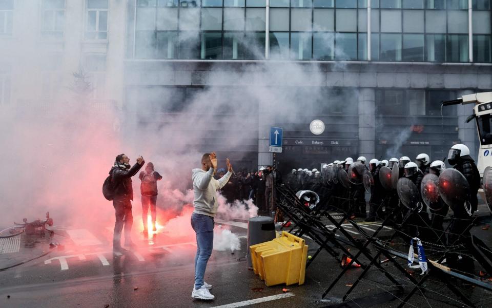 Demonstrators confront riot police during a rally to protest against Belgium government's measures to curb the spread of the Covid-19 - KENZO TRIBOUILLARD/AFP via Getty Image