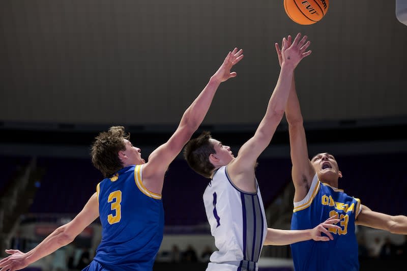 Lehi’s Cooper Lewis goes to the hoop between Orem’s Asher Young and Tikia Wesley in a 5A boys basketball state quarterfinal game at the Dee Events Center in Ogden on Wednesday, March 1, 2023. | Spenser Heaps, Deseret News