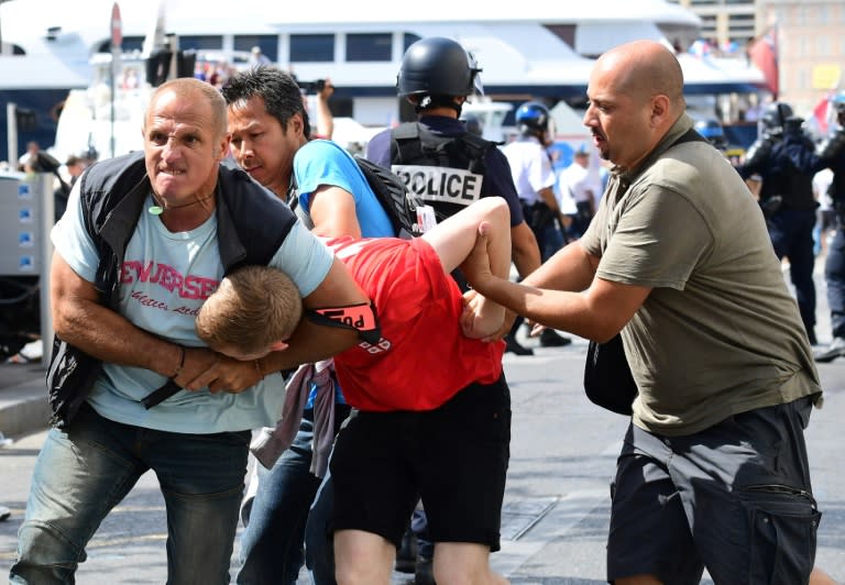 Police detain an England fan (C) following clashes between fans and police in Marseille, southern France, ahead of the Euro 2016 match between England and Russia