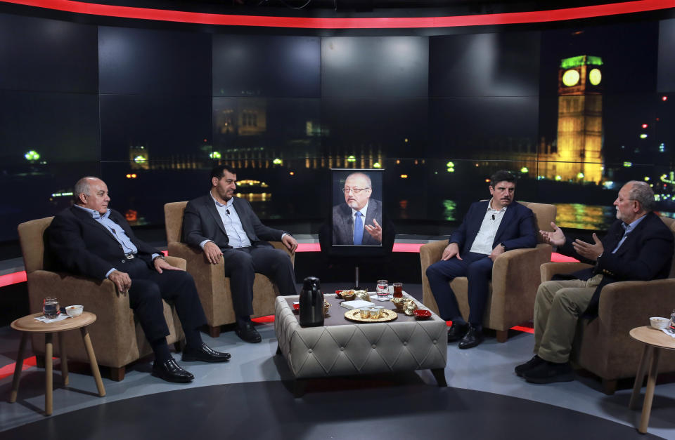 Friends, from left, Amro Darraj, Mohammed Kheir Moussa, Yasin Aktay and Azzam Tamimi gathered around an empty chair with a picture of Saudi writer Jamal Khashoggi placed on it, center, and speak during a live television program for London-based TV station al-Hewar, in Istanbul, late Thursday, Oct. 11, 2018. Khashoggi was supposed to appear on the show. The TV presenter Azzam Tamimi, a prominent Palestinian and a good friend of Khashoggi, told The Associated Press that the program was planned to discuss his new projects, his books and other issues.(AP Photo/Mucahid Yapici)