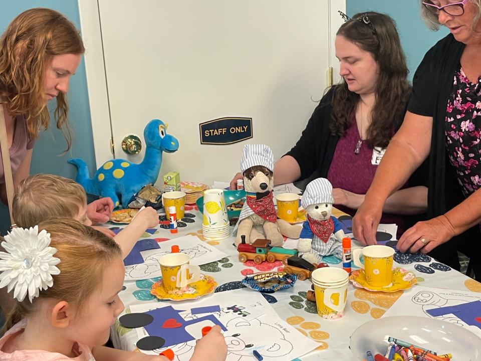 Dog and Bear helping out during a craft activity at the G Lynn Campbell Library on May 22, 2023.