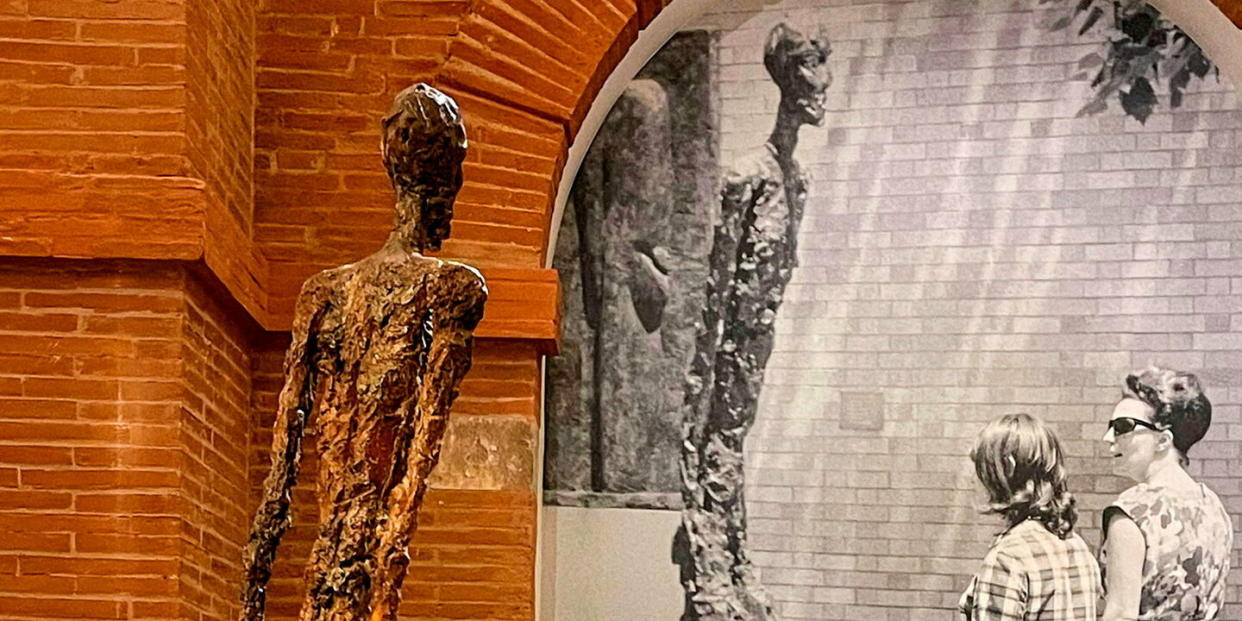 « L’Homme qui marche II » (1960) face à lui-même photographié dans le jardin du MoMA pour l’exposition « Albert Giacometti », à New York, en 1965.  - Credit: