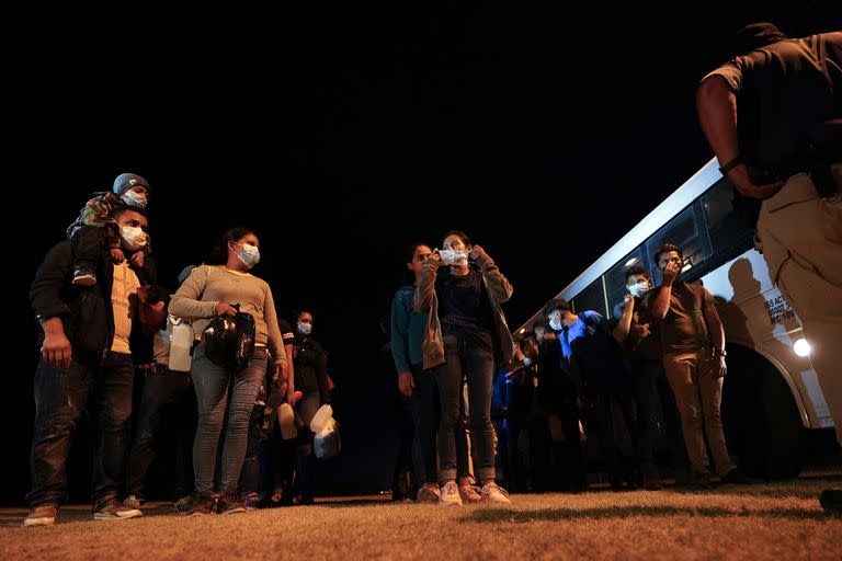 Un grupo de migrantes hace una fila en un puesto de acceso de la Patrulla Fronteriza de los EE. UU. Las familias con niños pequeños también suelen permanecer en los Estados Unidos mientras sus casos circulan por el congestionado sistema judicial de inmigración