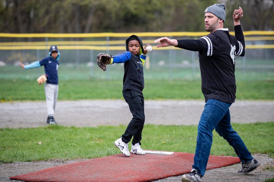 Monarchs' Dallas Mitchell, 6, learns how to throw a pitch from coach Pete Schneider during practice at Stoepel Park in Detroit on Tuesday, April 25, 2023.